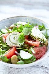 Summer Salad with Cream Cheese, green Olives, Tomatoes and fresh Basil. Bright wooden background. Close up.	