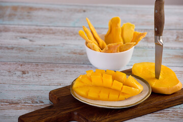 Healthy fruit snack of ripe mango and slices of sweet candied fruit. Close-up on a plate of sliced...
