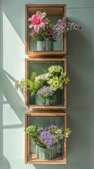 Vintage wooden crates with colorful fresh flowers in rustic pots against a light wall