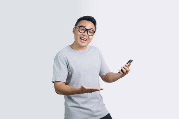 Portrait of surprised happy man looking to camera showing wow expression while holding smartphone