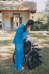 Obraz premium Young asian care helper with asia elderly woman on wheelchair relax together park outdoors to help and encourage and rest your mind with green nature. Help support yourself to learn to walk. walker