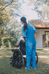 Obraz premium Young asian care helper with asia elderly woman on wheelchair relax together park outdoors to help and encourage and rest your mind with green nature. Help support yourself to learn to walk. walker