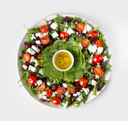 salad of beets, spinach, feta cheese, olive oil on a white background, top view