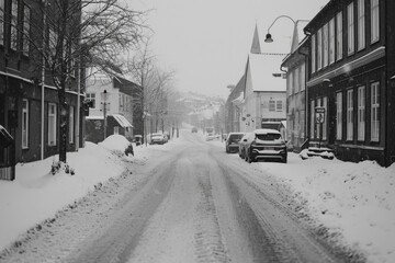 A black and white photo of a snowy street. Perfect for winter-themed designs and holiday projects - Powered by Adobe