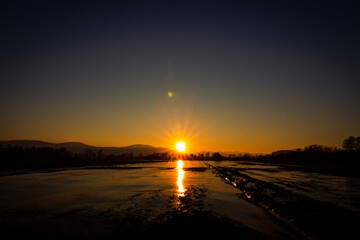 A sunset over the frozen farmlands