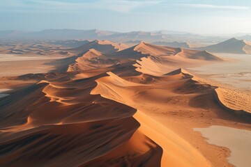 Fototapeta na wymiar A stunning aerial view of vast sand dunes in the desert. Perfect for travel brochures and articles about nature and adventure