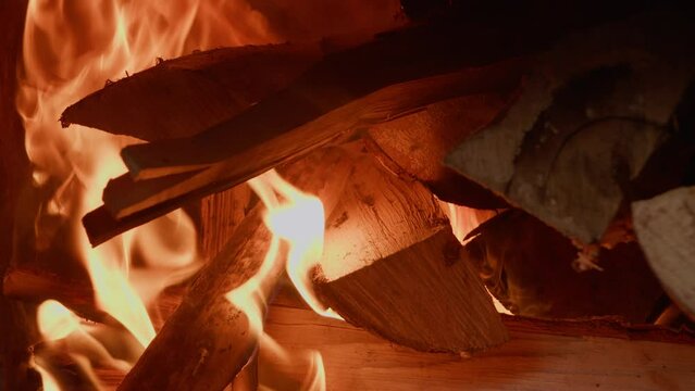 Firewood burning in the stove turns red with flames. Close-up.