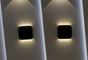 Two wall lights with symmetrical highlights on the wall.