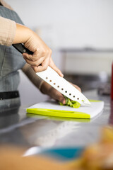 chopping the leaves of a fresh lettuce, on a cutting board and a sharp knife, kitchen utensil,...