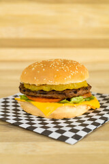 one exquisite classic hamburger with cheese, bread, meat and vegetables, studio photo of unhealthy fast food, restaurant menu