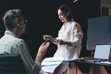 Asian female using application on digital tablet during brainstorming working process with...