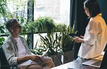 Male and female analyzing productive strategy while brainstorming in coworking space, professional...