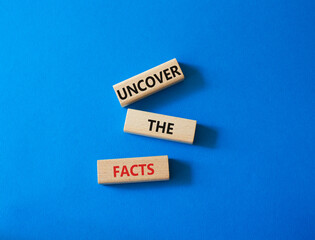 Uncover the Facts symbol. Concept word Uncover the Facts on wooden blocks. Beautiful blue background. Business and Uncover the Facts concept. Copy space