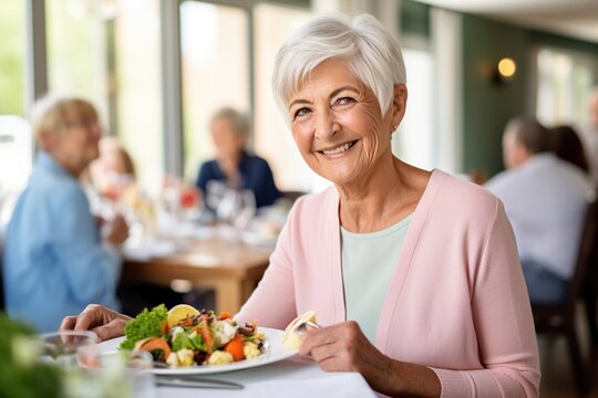 Smiling senior woman eating a salad in a restaurant