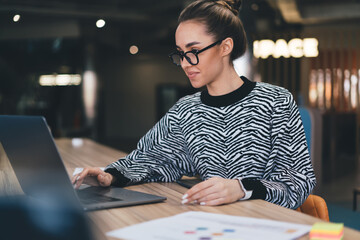 Focused woman working on laptop in cafe