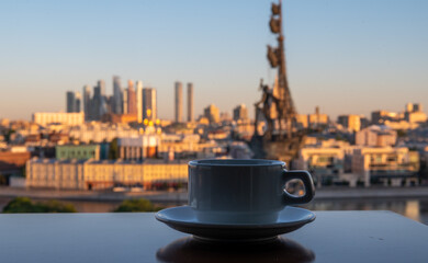 A cup of coffee on a table in a summer cafe with a panoramic view of the center of the Russian capital