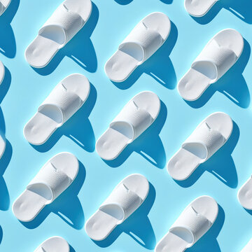 
Trendy sunlight Summer pattern made with white slippers on bright light blue background. Minimal summer concept, dynamic shot angle, stock photo
