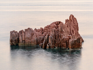 Fototapeta na wymiar Geological feature called Rocce Rosse (red rocks) in Arbatax at the sunrise; east coast of Sardinia, Italy