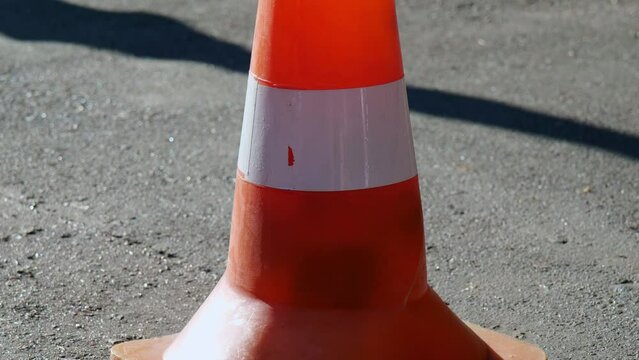 a traffic cone stands on the asphalt on a sunny day, a shot from the bottom up