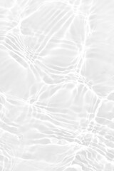 White water with ripples on the surface. Defocus blurred transparent white colored clear calm water surface texture with splashes and bubbles. Water waves with shining pattern texture background.