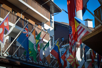 Flags of different countries against the background of sunlit buildings