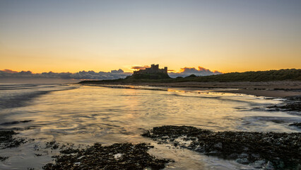 Beautiful landscape image of Northumberland beach in Northern England during Winter dawn with deep...