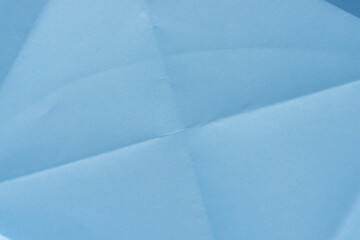 folded light blue crafting paper background with crease lines