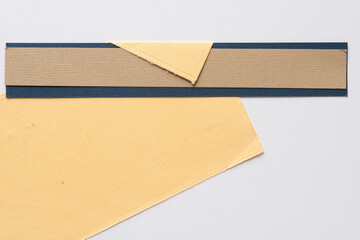 yellow paper with flap and striped paper shapes on white 