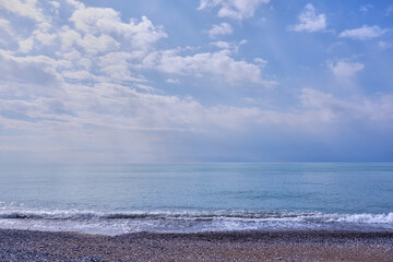 Beach on the Black Sea coast, the blue color of the water merges with the blue sky and clouds