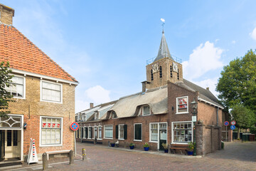 Street with a view of the old church tower in the picturesque rural village of Linschoten.