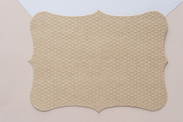 brown scalloped die-cut card with embossed pattern on beige paper