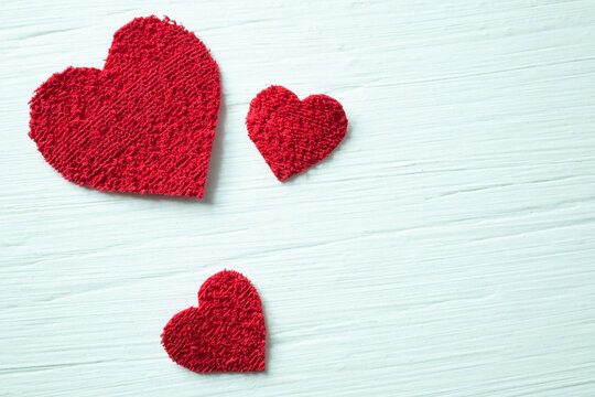 Red hearts on a white textured table.