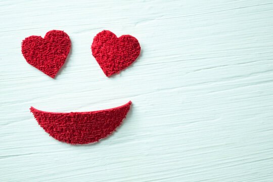 Smiley face with heart eyes made with pieces of plush.