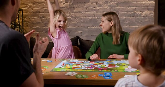 happy playful family spending time together and playing board games at home