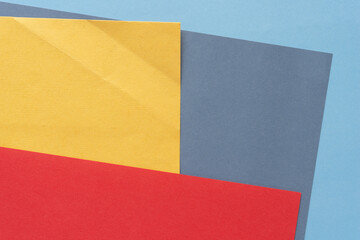layered blue, gray, yellow, and red paper background