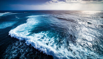 An aerial view shows ocean waves against a blue water background.