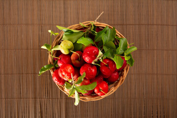 Freshly Harvested Organic Acerolas in a Basket on a Wooden Textured Table