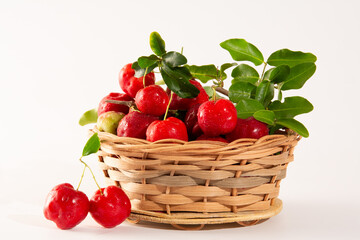 Freshly Harvested Organic Acerolas in a Basket on a white table and clean background in front view
