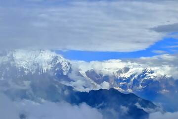 Fototapeta na wymiar Majestic Veil: Annapurnas' Cloud-Kissed Giants