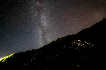 étoiles de la voie lactée qui illuminent le ciel de la nuit avec une colline en avant plan en...