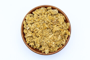 Jaggery in a wooden bowl on white background top view 