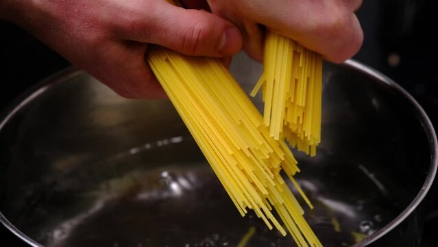 Close-up of throwing pasta into boiling water