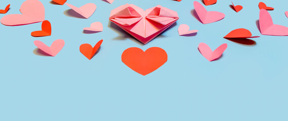 Pink paper hearts, origami, arranged on a light background. Top view. Concept for Valentine's Day. Mother's Day. Copy space.