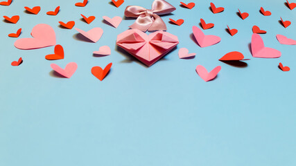 Pink paper hearts, origami, arranged on a light background. Top view. Concept for Valentine's Day....