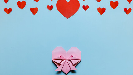 Pink paper hearts, origami, arranged on a light background. Concept for Valentine's Day. Mother's Day. Copy space.