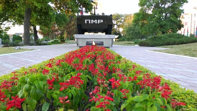 PMR - translation from Russian of the inscription on the frontal armor of a combat vehicle. memorial complex in honor of fallen war heroes. flowerbed with red flowers and eternal flame