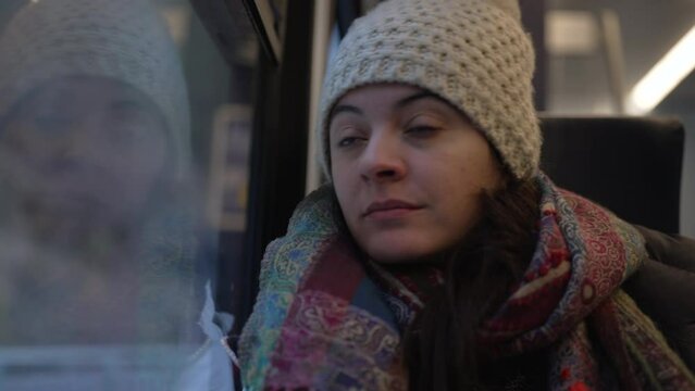 Commuter woman wakes up from nap inside train transportation having missed stop and getting up from seat. Sleeping passenger waking up