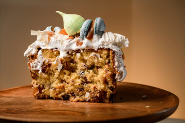 Piece of cake with cream, fruit and almond filling on a wooden stand