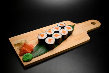 Portion of sushi rolls with salmon served on leaves