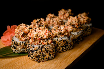 Sushi rolls with shrimp meat and caviar rolled in sesame, side view